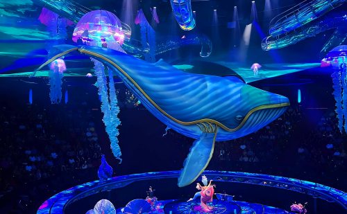 Flying Whale soaring in the underwater scene at 'The Awakening' show, Wynn Las Vegas, highlighting advanced aerial choreography and atmospheric stage design.